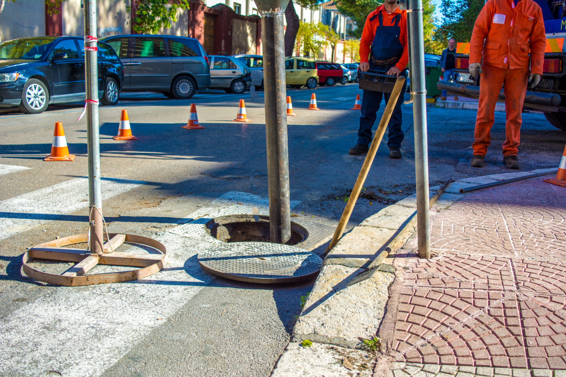 A Man Is Commanding A Machine For Cleaning The Manholes In The Street