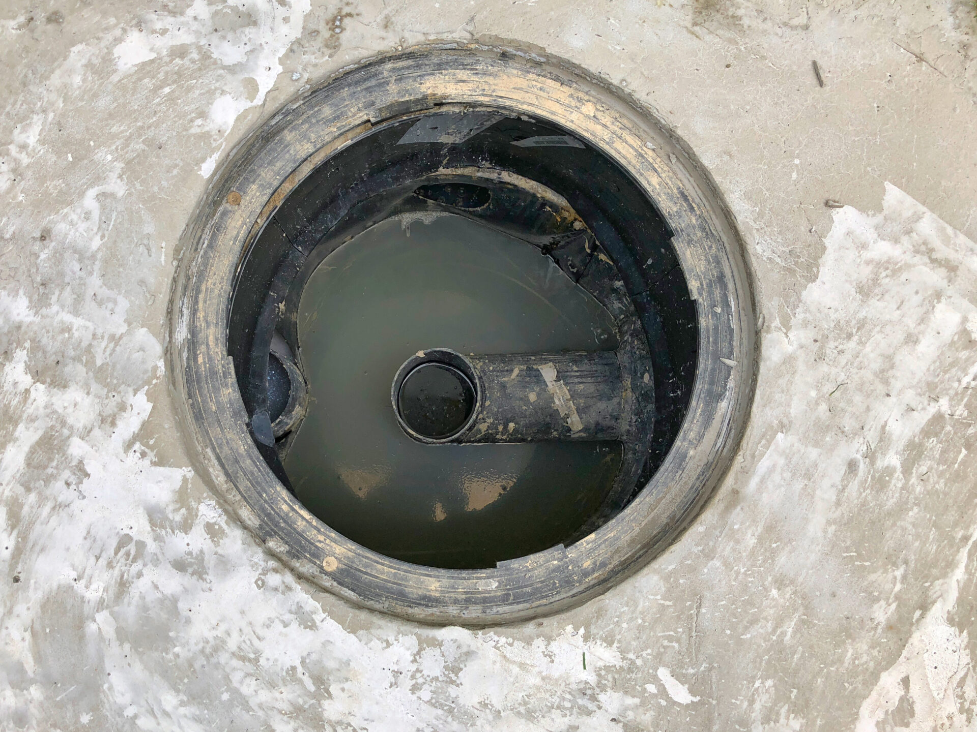 A hole of grease trap with the drain system around the house.