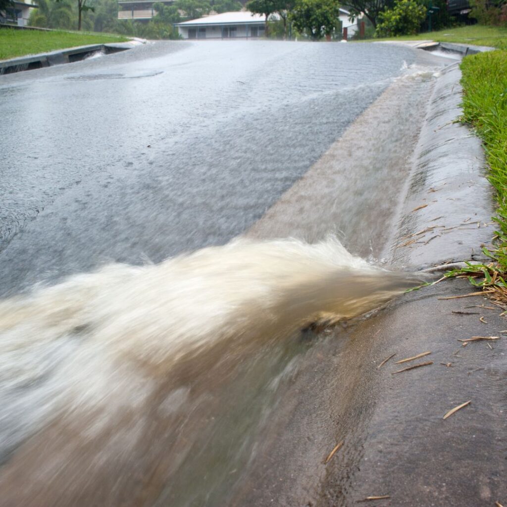 a flooded roadway with rushing water