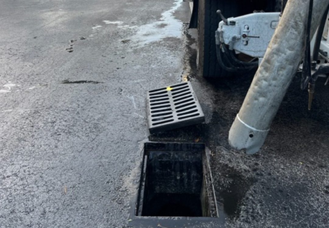 a truck using a tool in a storm drain