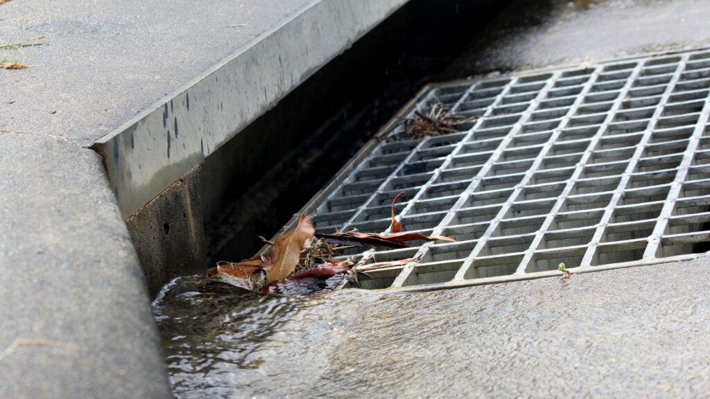a storm drain on a public sidewalk